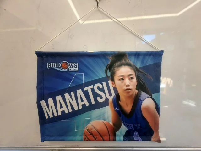 バスケットボールチームの選手ビジュアルをデザインした上下パイプ付きタペストリー。壁面装飾や選手応援、会場演出に活用。
