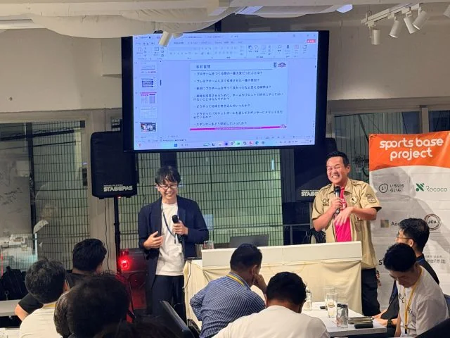 sports base fukuokaのイベント会場で、スクリーンを使った講演を参加者が聴いている様子